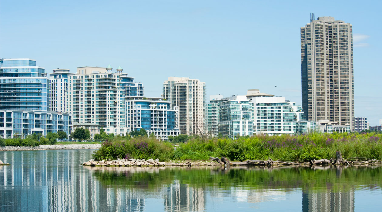 Skyline of condominiums in distance, water and island in front