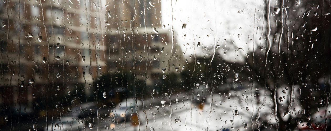 Rain on a window, blurry condo in distance