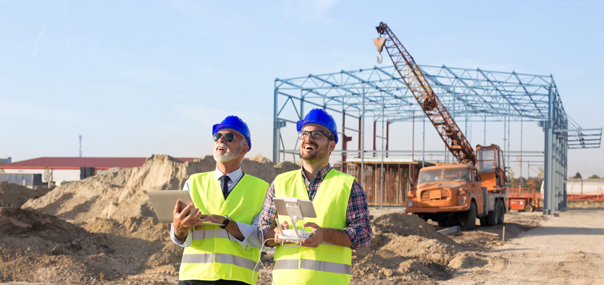 Engineers flying a drone over construction site.