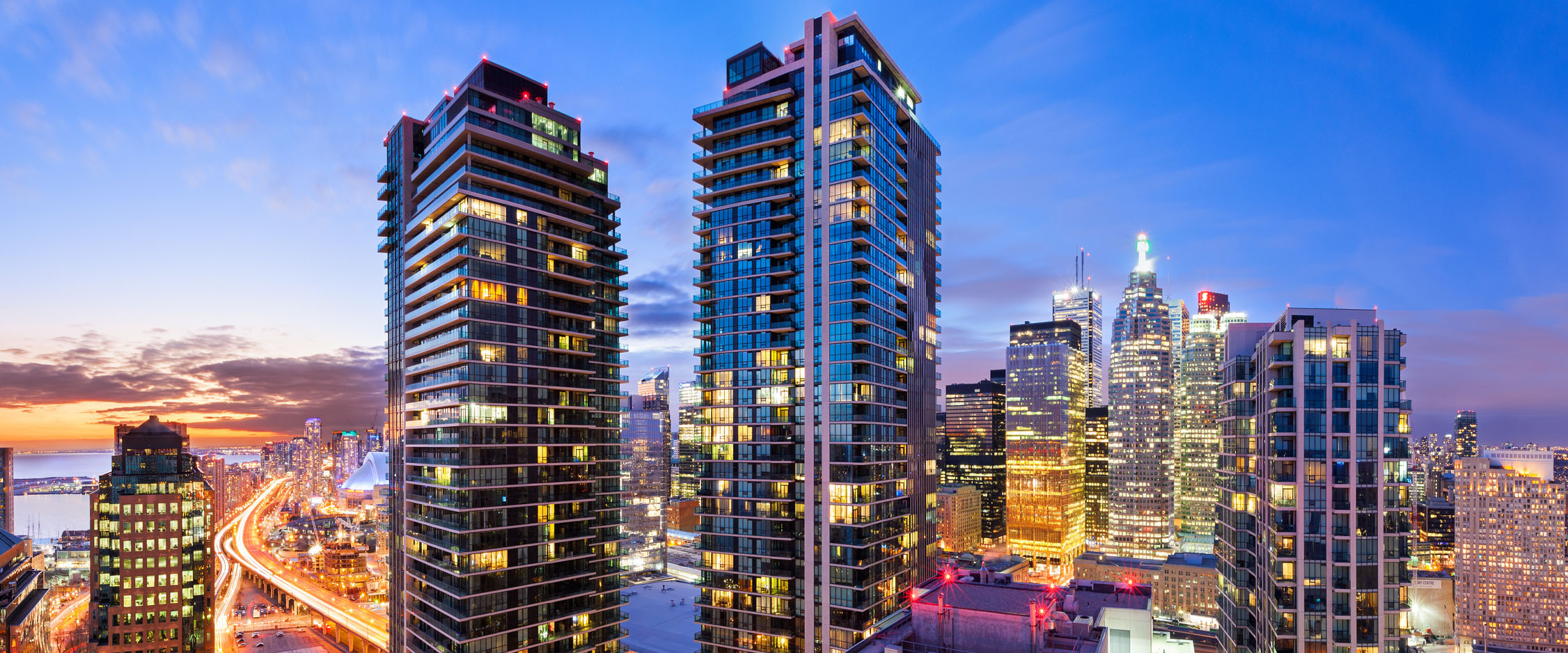 Long exposure panoramic photo of downtown Toronto cityscape and condominium towers at sunset and twilight.